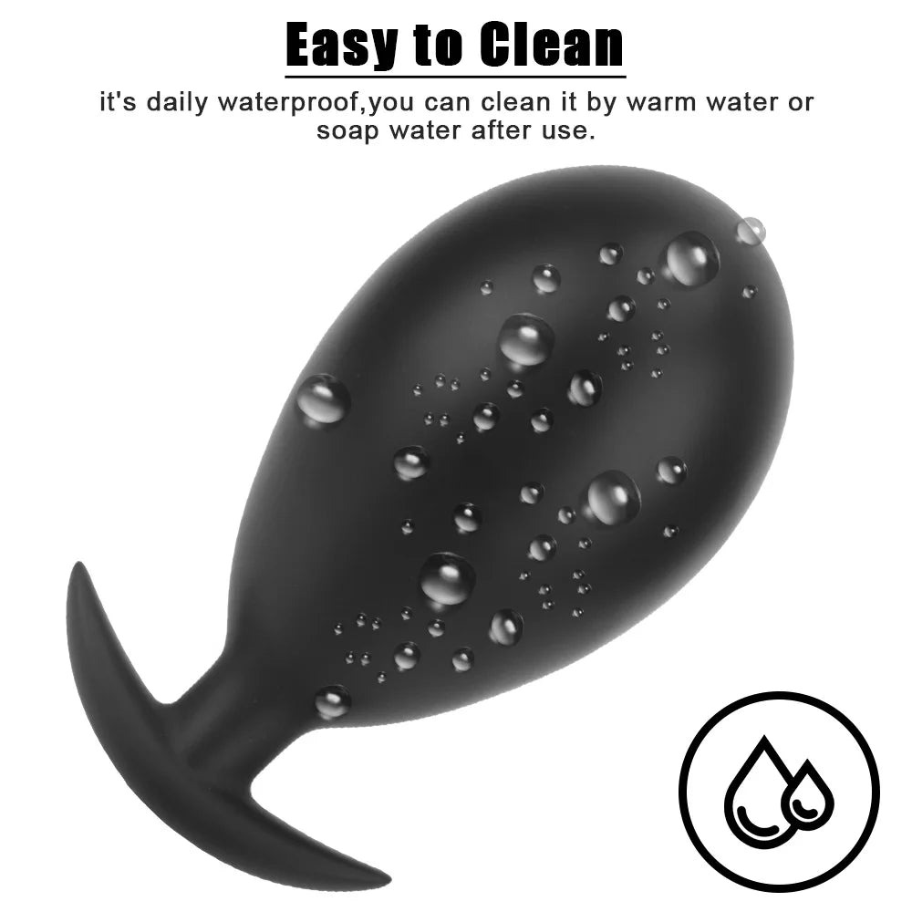 Black inflatable anal plug with water droplets beading on textured surface