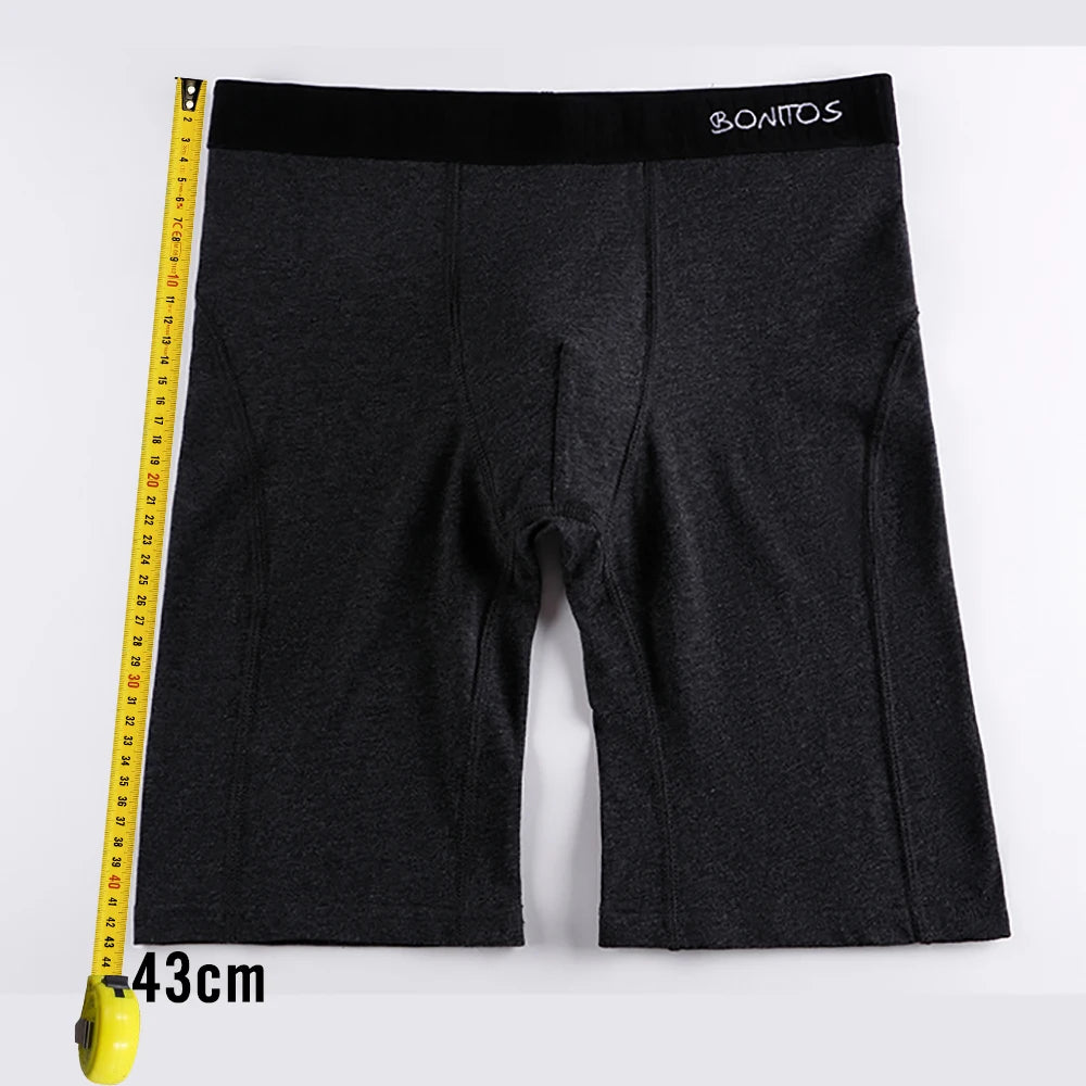 Men's long boxer briefs in dark gray with elastic waistband, shown with measuring tape.