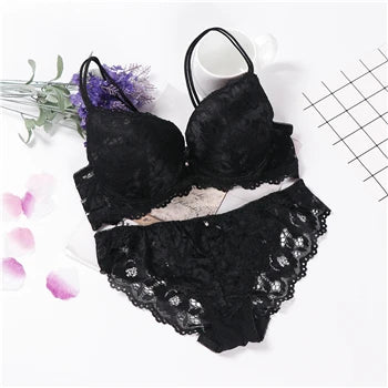 Black underwired push-up lace bra set with matching lace panties, laid out