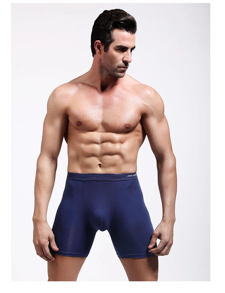 Blue compression boxer briefs on model, mid-thigh length with elastic waistband