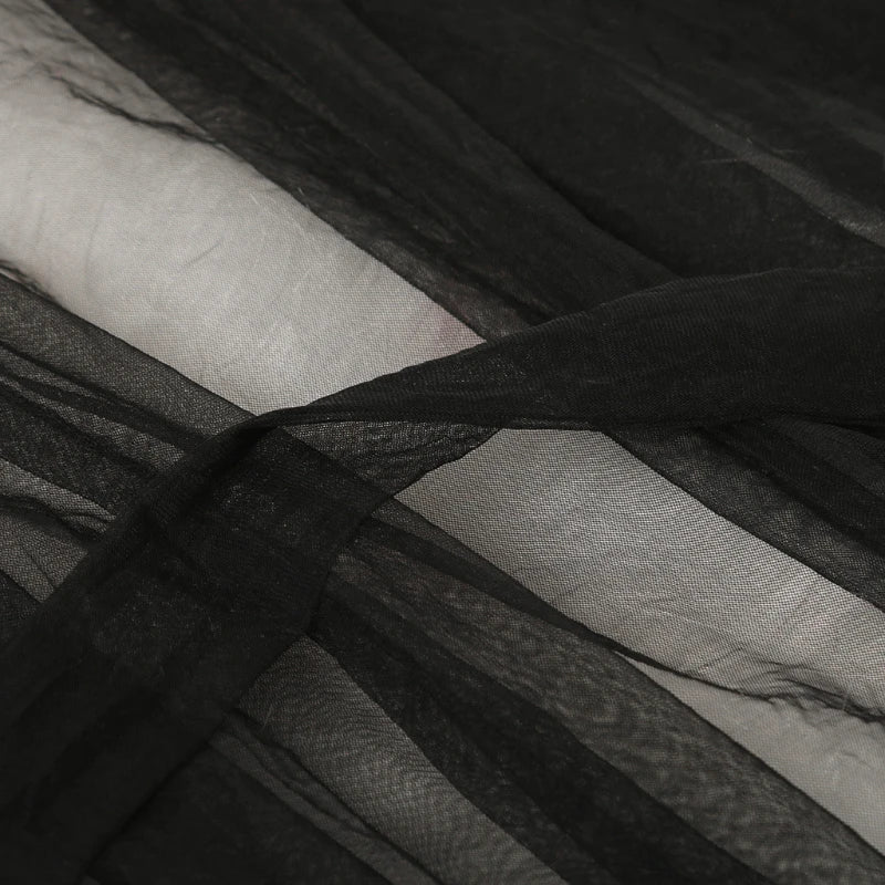 Close-up of black sheer mesh fabric with subtle lace or striped weave texture