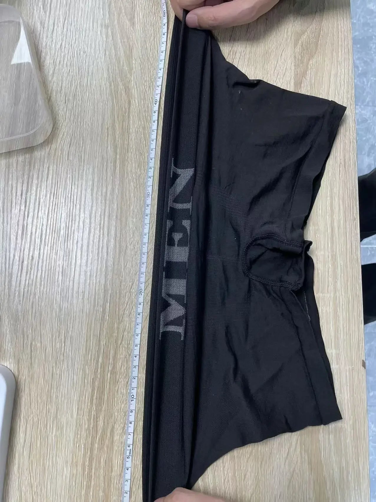 Black stretch boxer briefs laid flat, logo waistband and front pouch visible