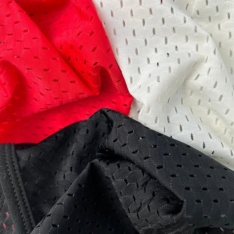 Red and white sheer mesh pouch brief fabric close-up with dot texture