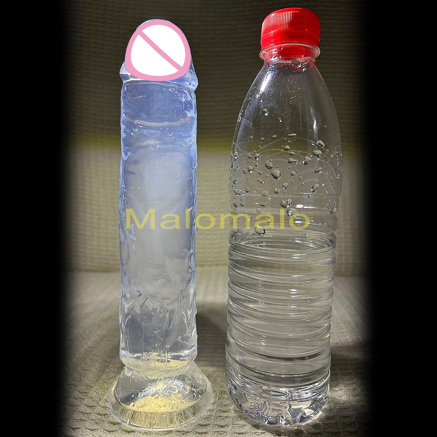Blue transparent jelly dildo with suction cup beside clear bottle