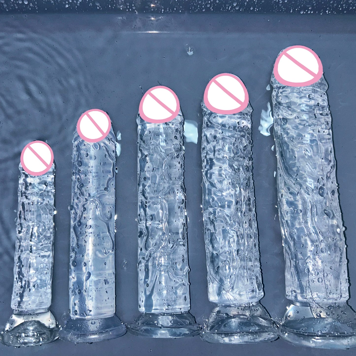 Transparent jelly sex toy with suction base, clear blue body and pink tip cap