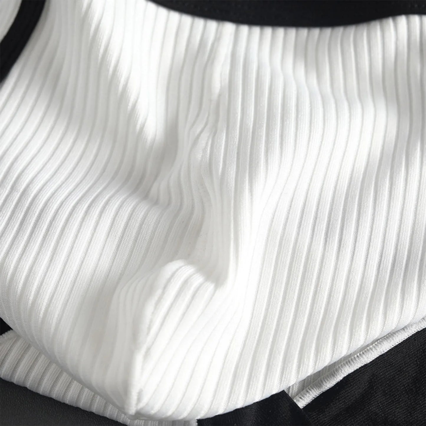 Close-up of striped U-pouch brief in white ribbed fabric with black waistband trim