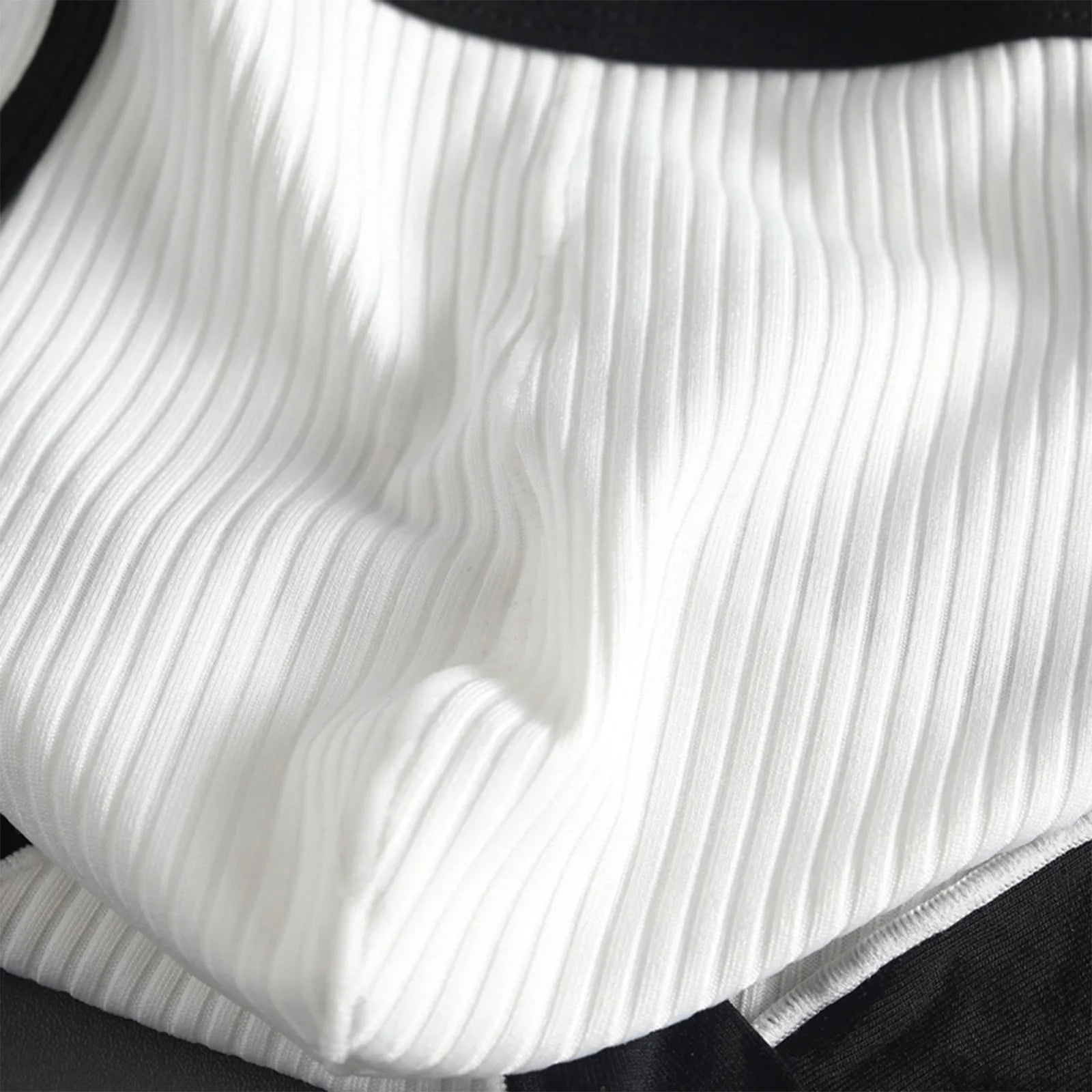 Close-up of striped U-pouch brief in white ribbed fabric with black waistband trim