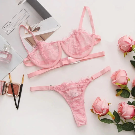 Pink lace push-up bra and matching thong brief set laid flat on a surface.