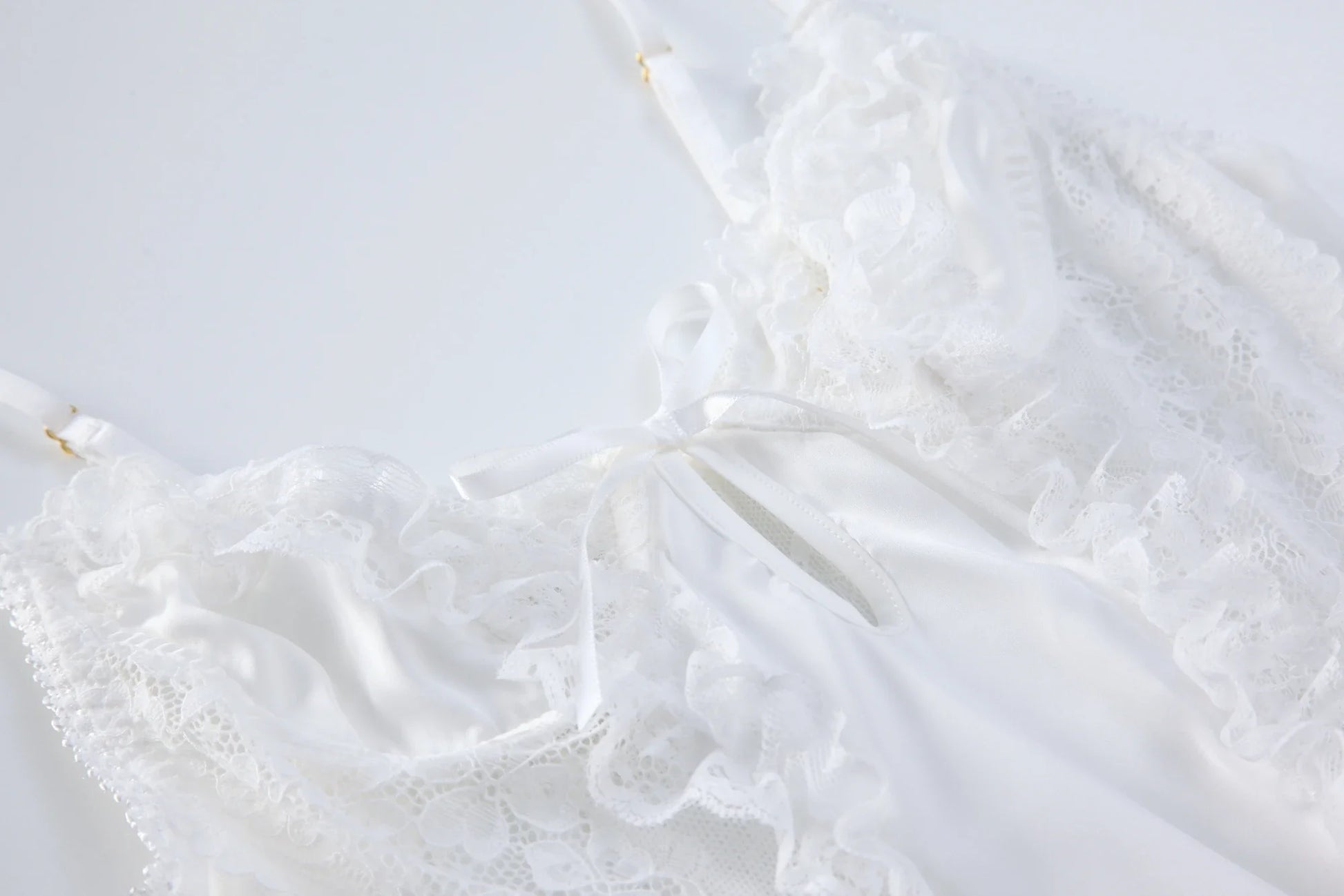 White lace backless babydoll bodysuit with ruffled tiered skirt and bow detail