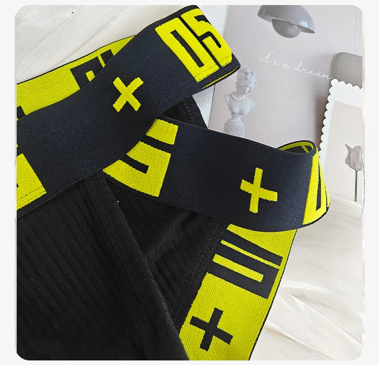 Black stretch brief close-up with neon yellow logo elastic waistband.