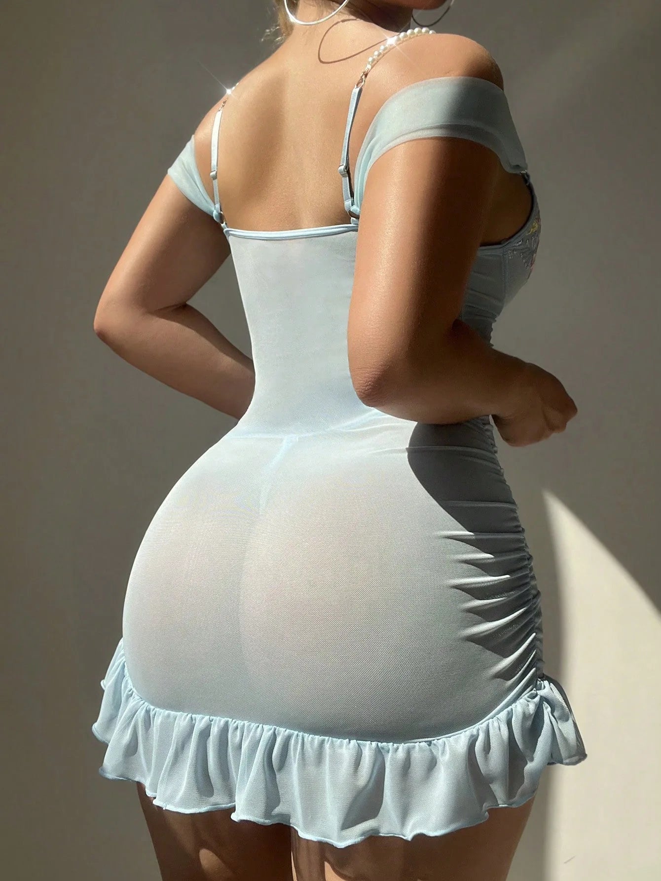 Light blue sheer mesh lace nightgown bodysuit viewed from back with ruched ruffle hem