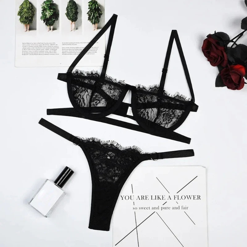Black lace push-up bra and matching thong brief set laid flat, with lace accents.