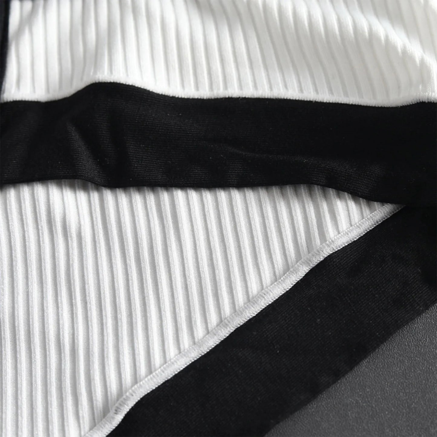 Close-up of white ribbed brief with black band and angled black panel seam