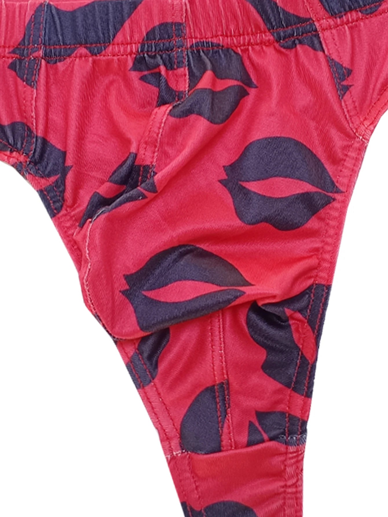 Close-up of red low-rise thong with dark navy lips print and stitched center seam.