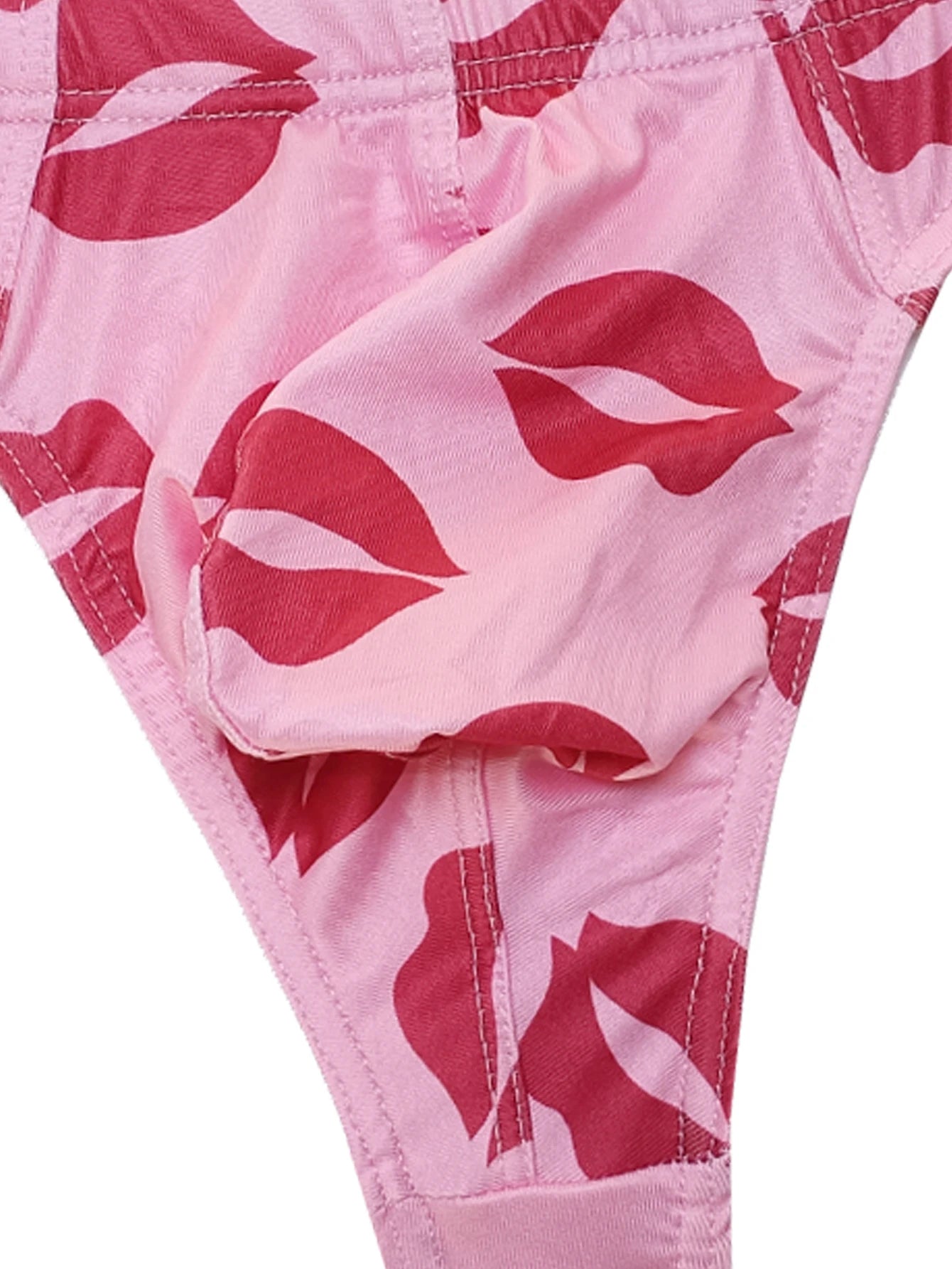 Close-up of light pink low-rise thong with red lips print fabric.