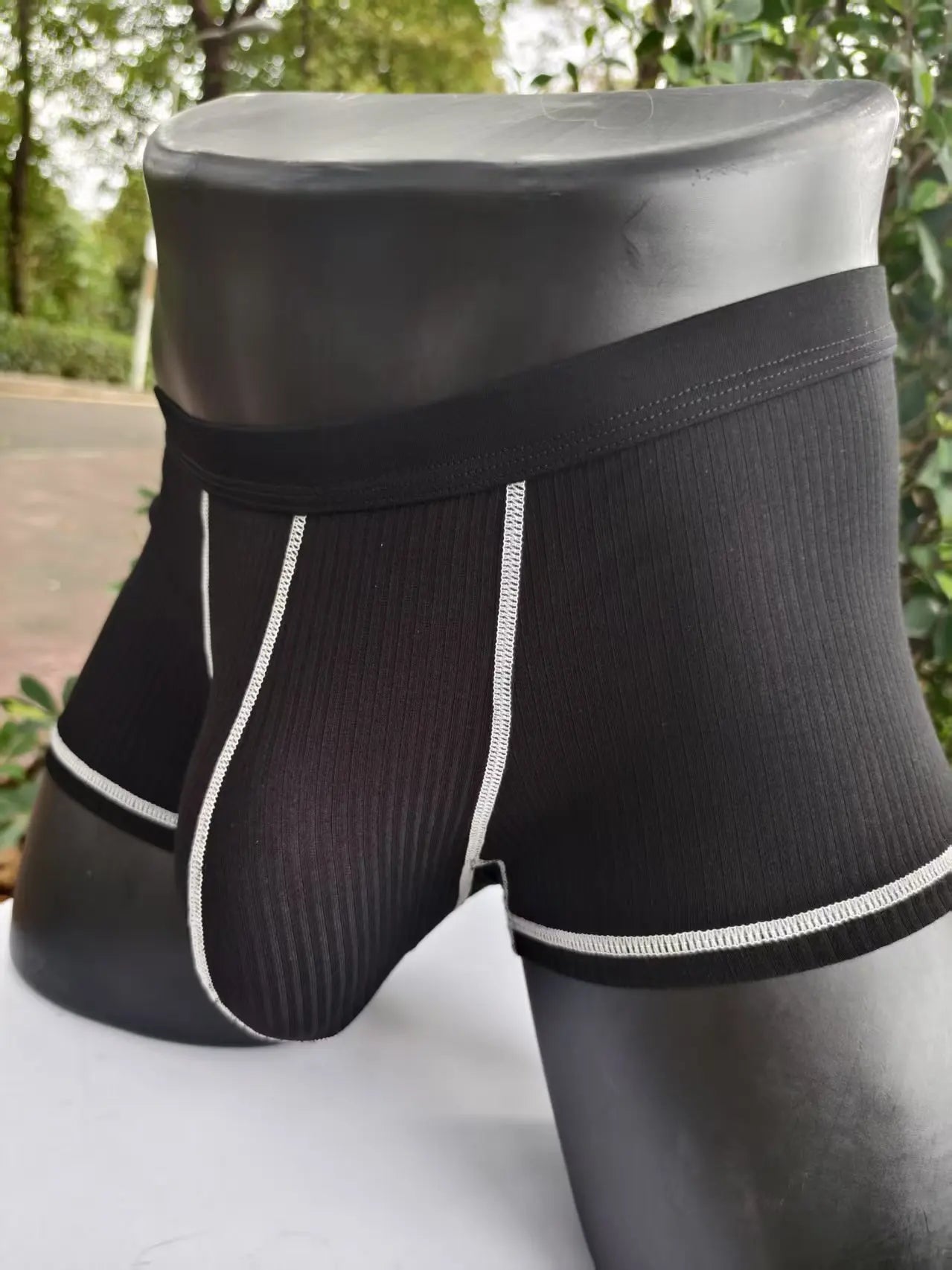 Black ribbed boxer shorts with wide elastic waistband and white contrast piping, front pouch