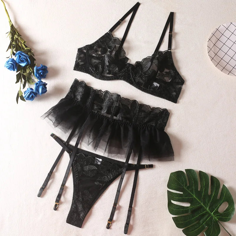 Black strappy embroidered mesh lingerie set with bra, sheer ruffled skirt, thong and garters