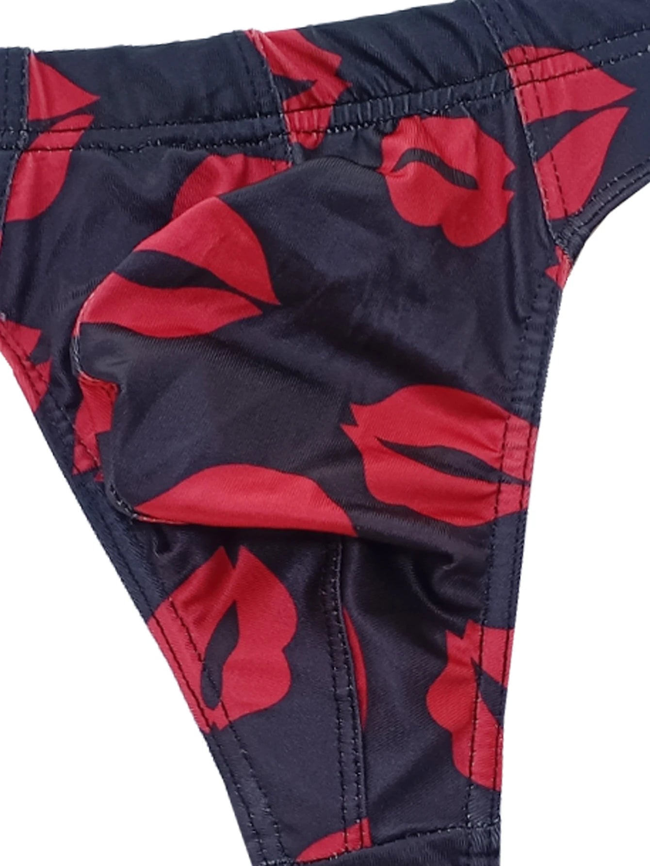 Close-up of dark navy low-rise thong with red lips print and elastic leg edge.