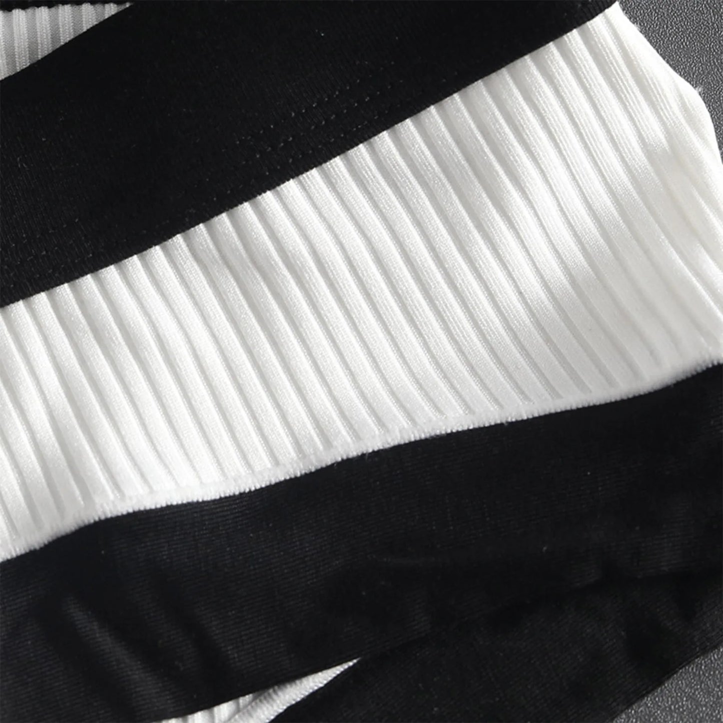 Close-up of white ribbed brief with black waistband and side seam trim
