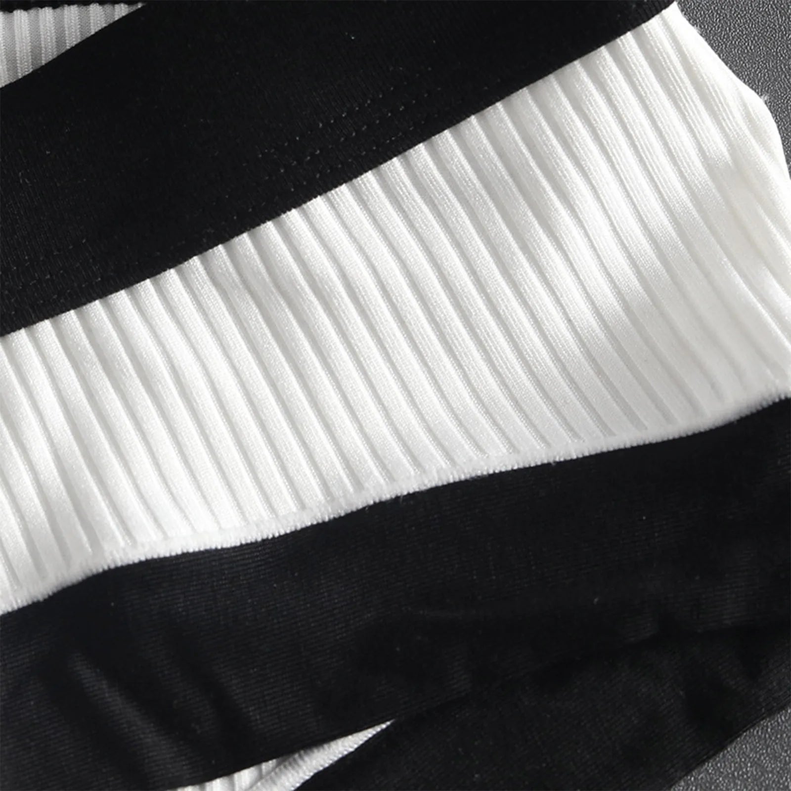 Close-up of white ribbed brief with black waistband and side seam trim